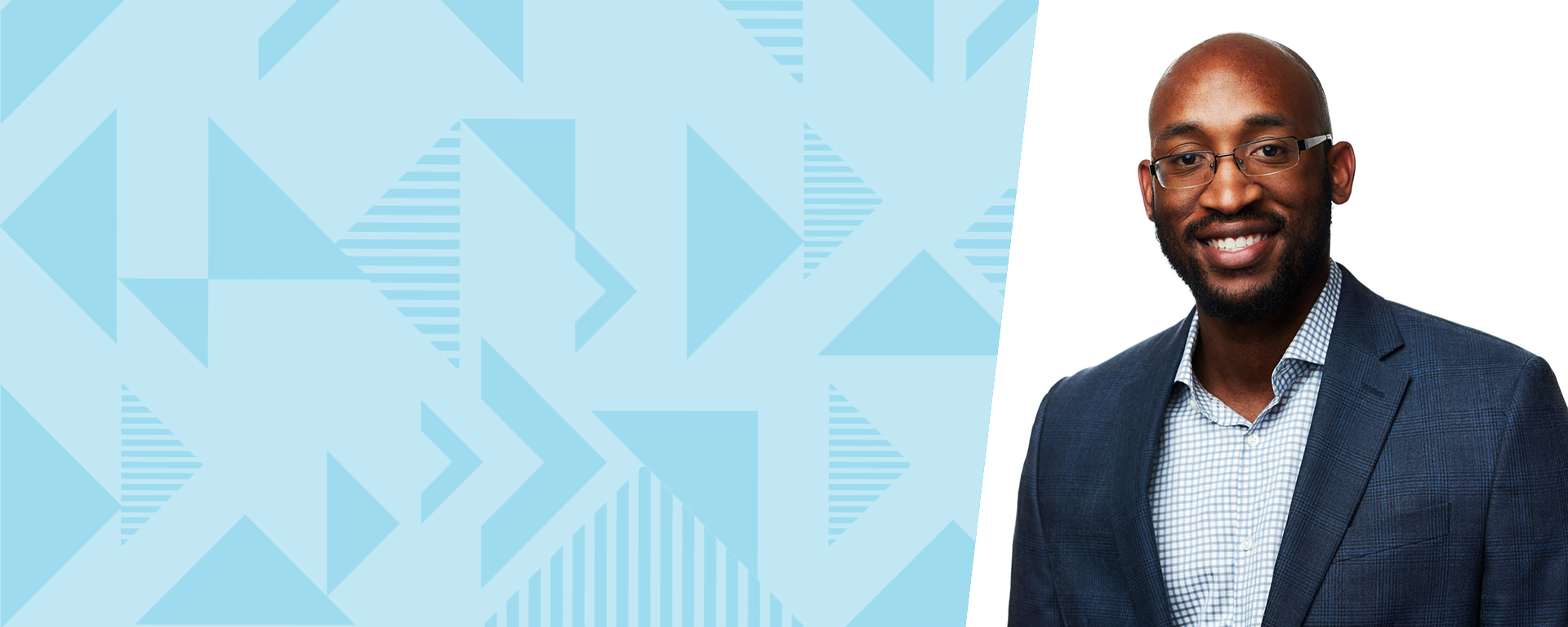 Capital One associate Jerich stands in front of a white background, with a two-toned blue triangular background to the left of his image