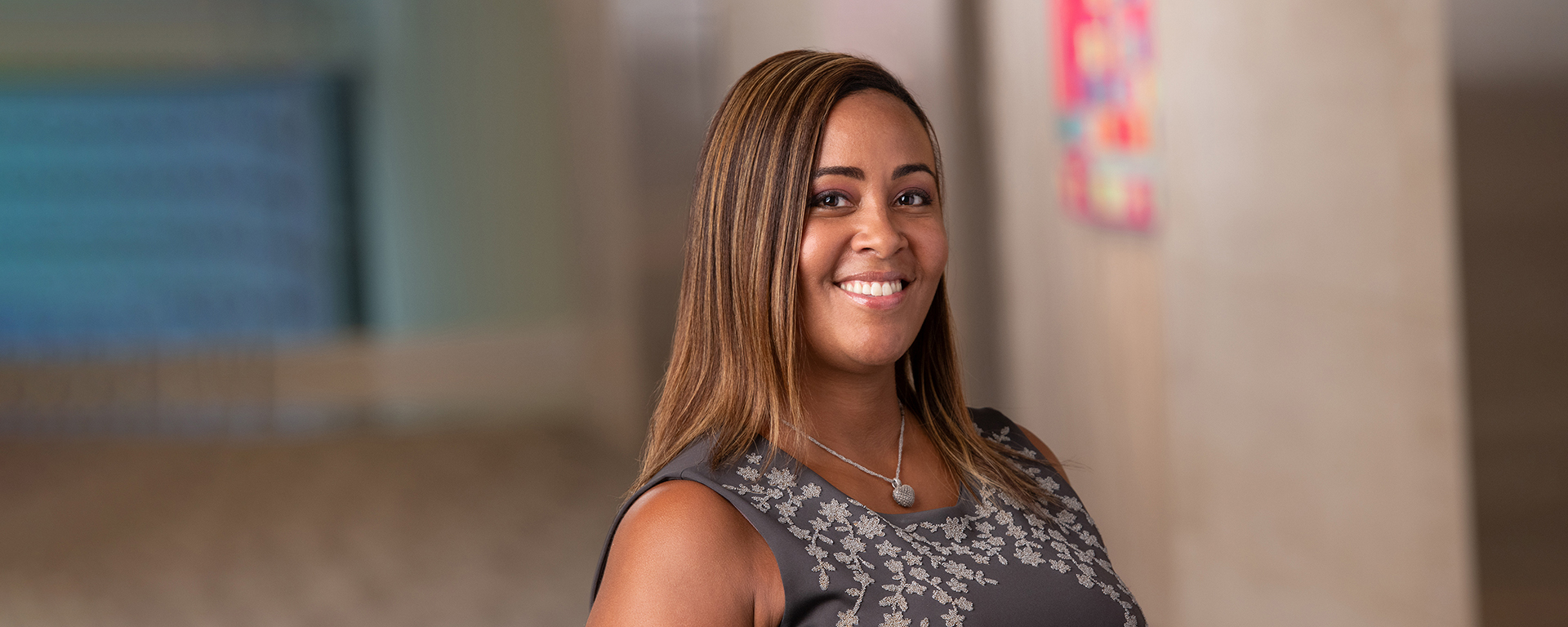 Judith, a Capital One Veteran, stands inside and smiles, talking about her experience at Capital One as a veteran working mom in school