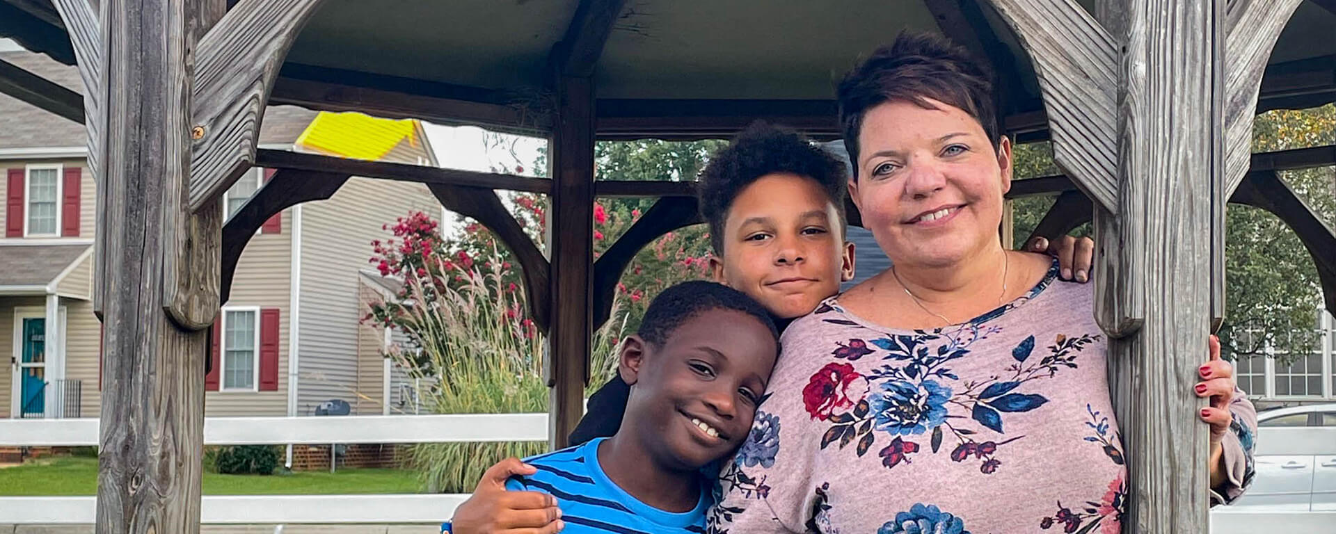 Capital One associate and working mom Susan stands under a gazebo with her two sons