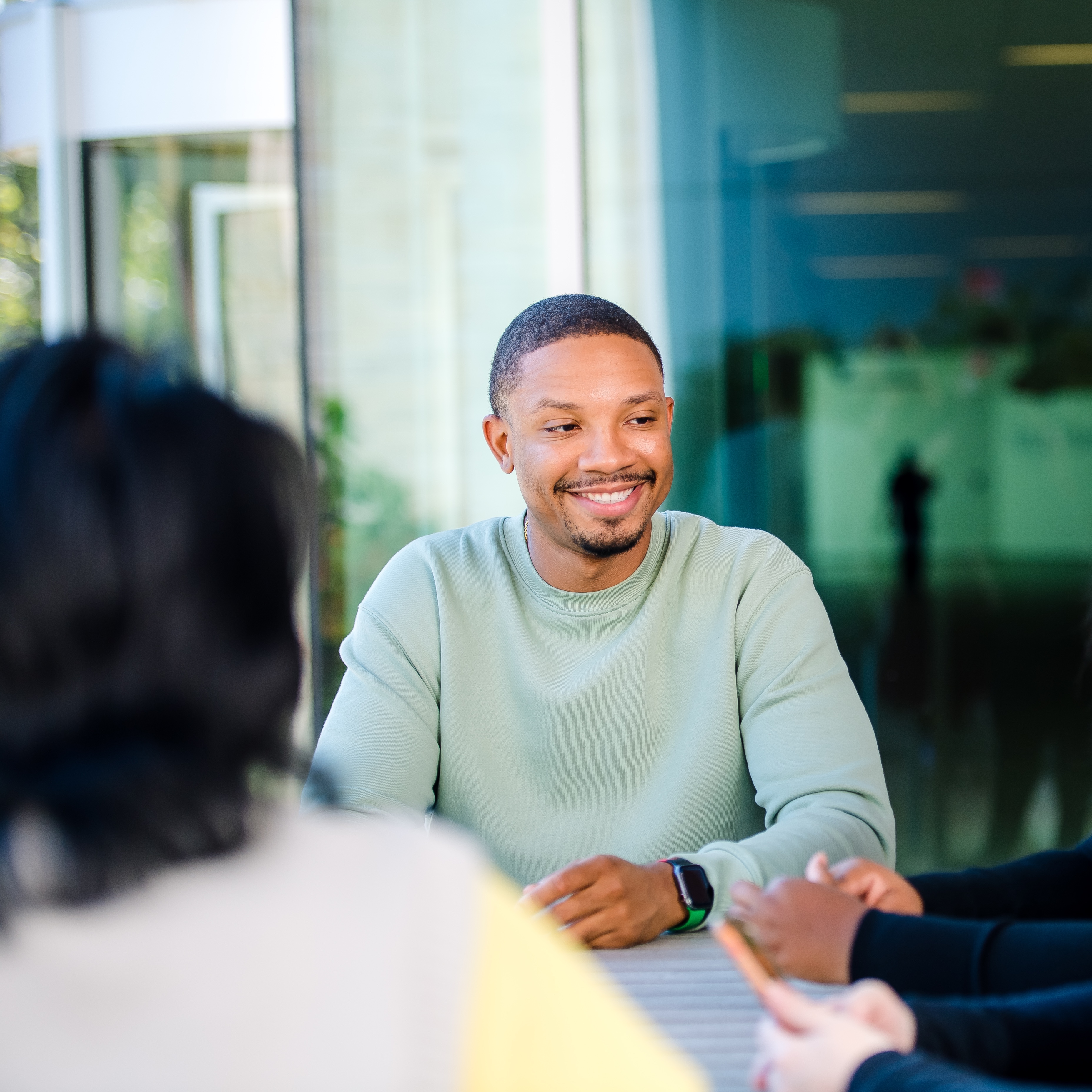 A Capital One MRP associate sits at a table talking with other associates
