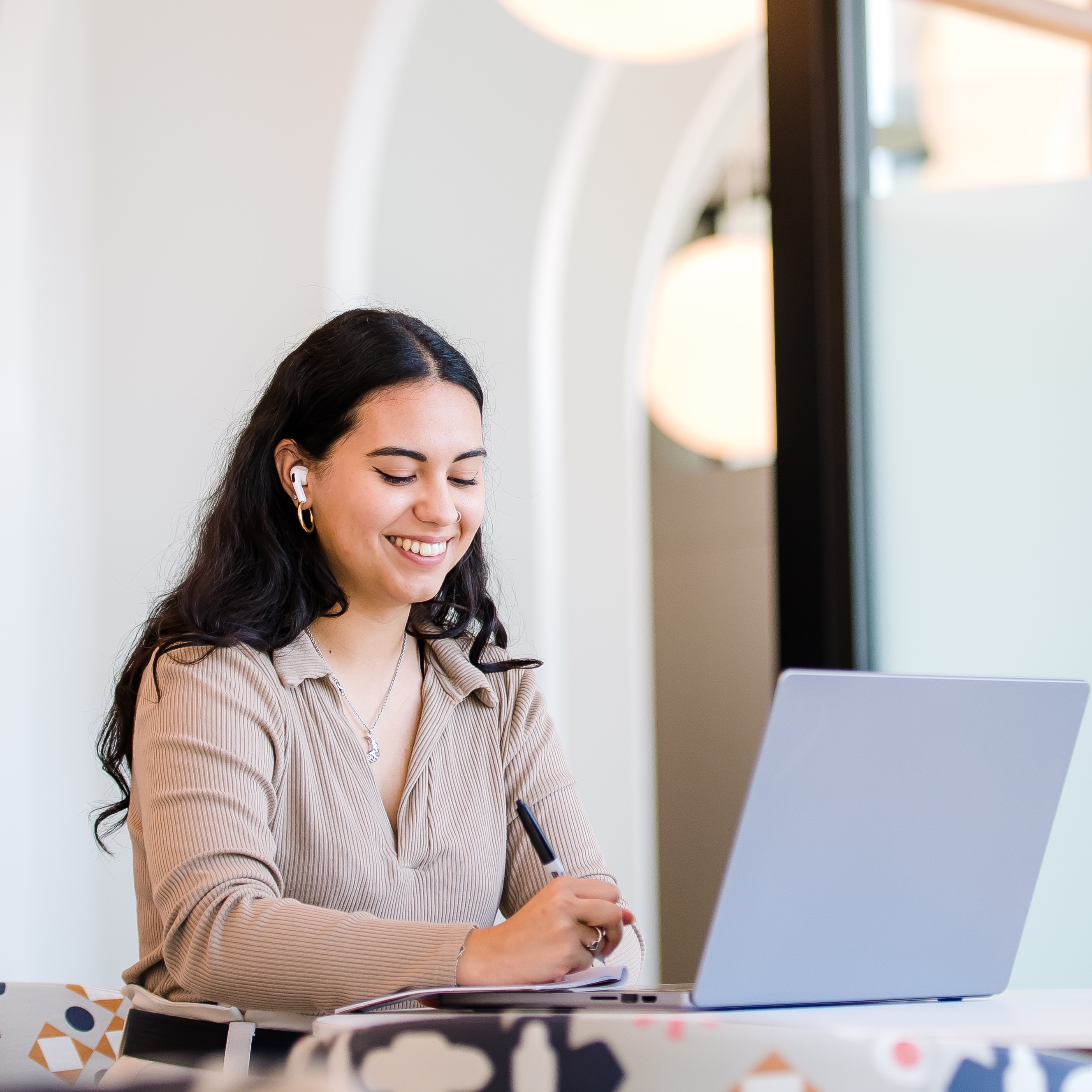 Capital One PDP associate sits at a table and works on her laptop