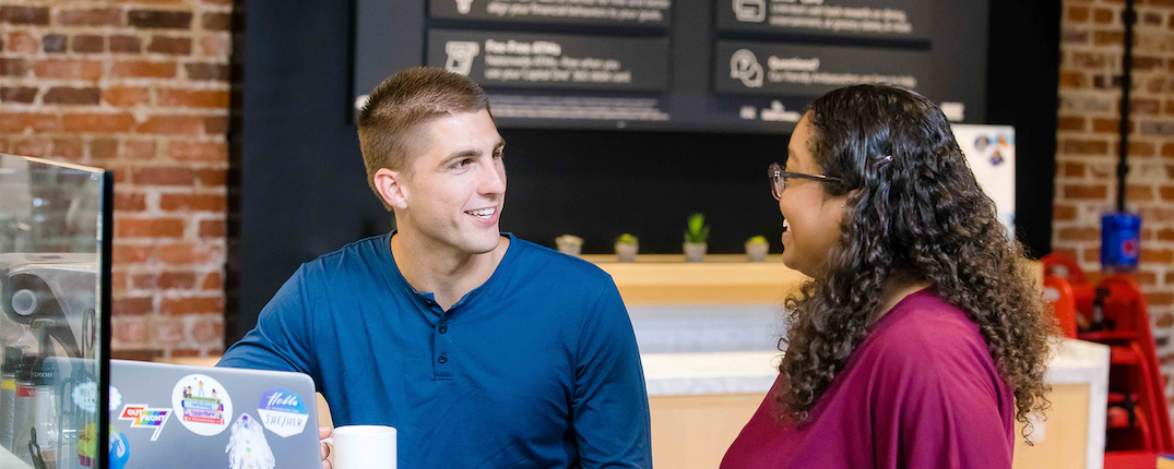 Two people talk in a Capital One Cafe