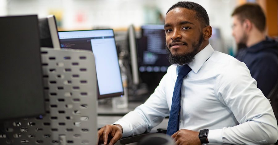 Byron, seated at his computer
