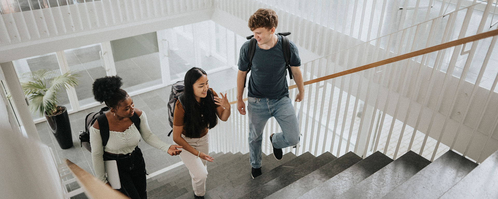 Three Capital One Students & Grads associates walk up a stairwell talking