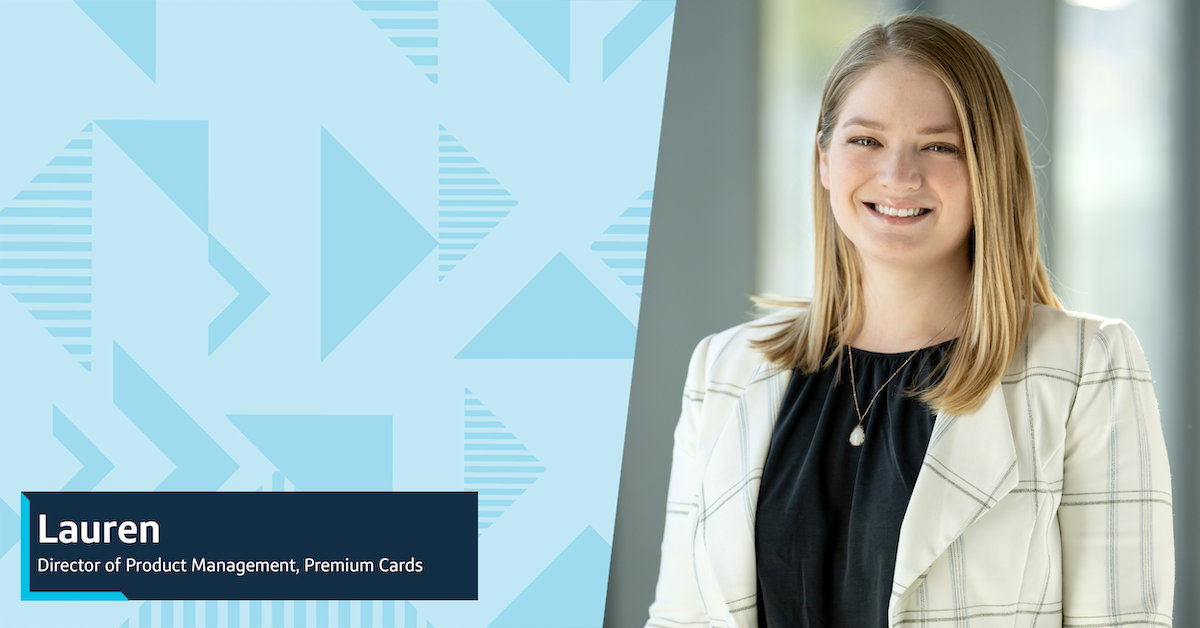 Lauren, a Capital One Product Manager, smiles wearing a black blouse and white checked blazer against a gray background