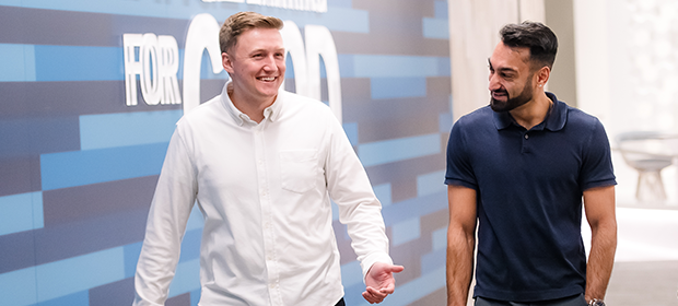 Two Capital One Strategy Consulting associates walk down a hall talking