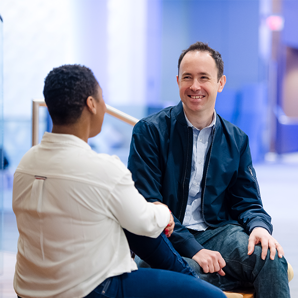 Capital One Strategy Consulting leader sits and talks with another associate